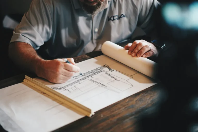 Architecte annotant des plans sur sa table de travail
