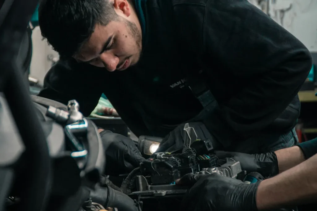 Mécanicien automobile travaillant sur un moteur dans son garage