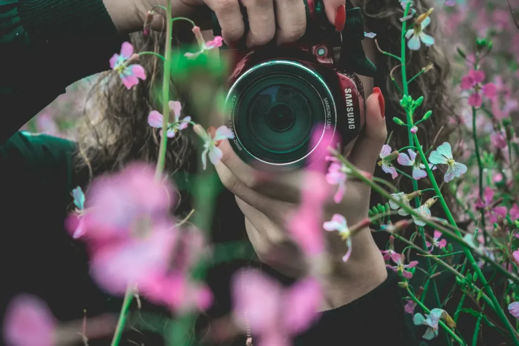 Photographe professionnelle cadrant une prise de vue en extérieur