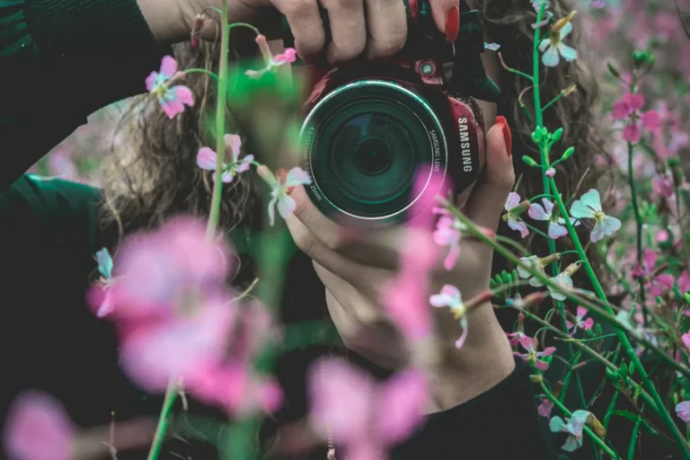 Photographe professionnelle cadrant une prise de vue en extérieur