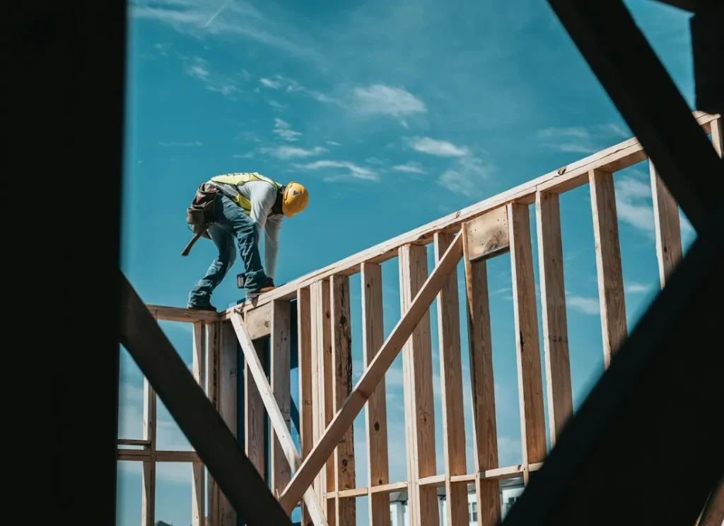 Ouvrier du bâtiment en hauteur sur une charpente en bois